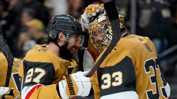 Vegas Golden Knights defenseman Shea Theodore celebrates with goaltender Adin Hill.